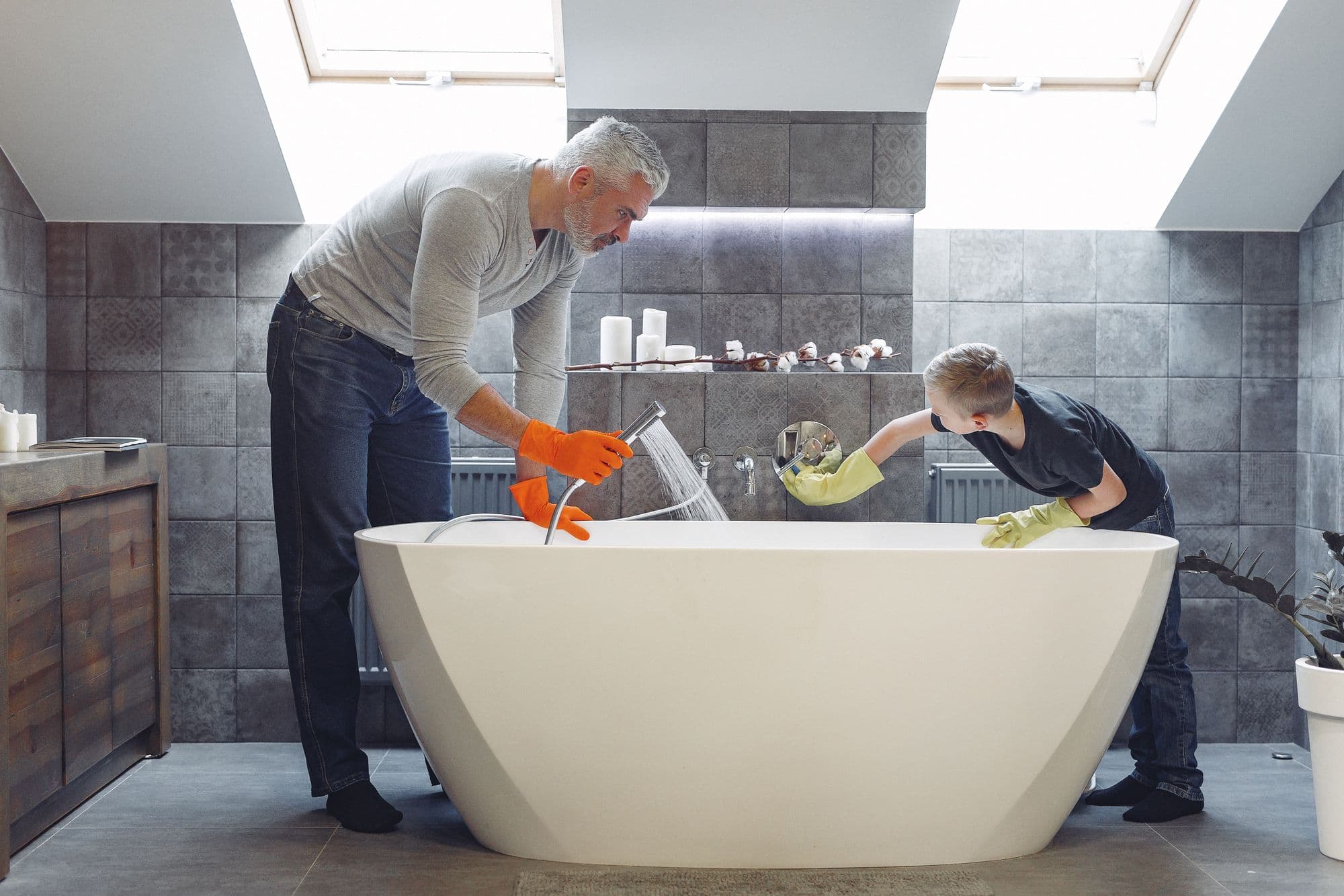 Deux artisans installent une baignoire îlot dans une salle de bain en rénovation