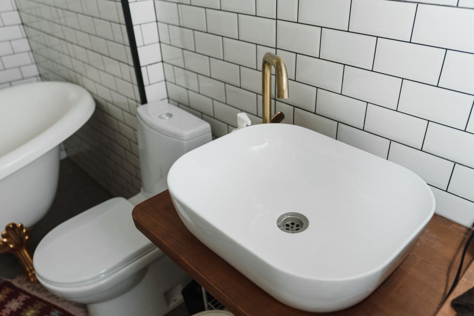 La salle de bain terminée : faïence blanche, vasque et robinetterie laiton